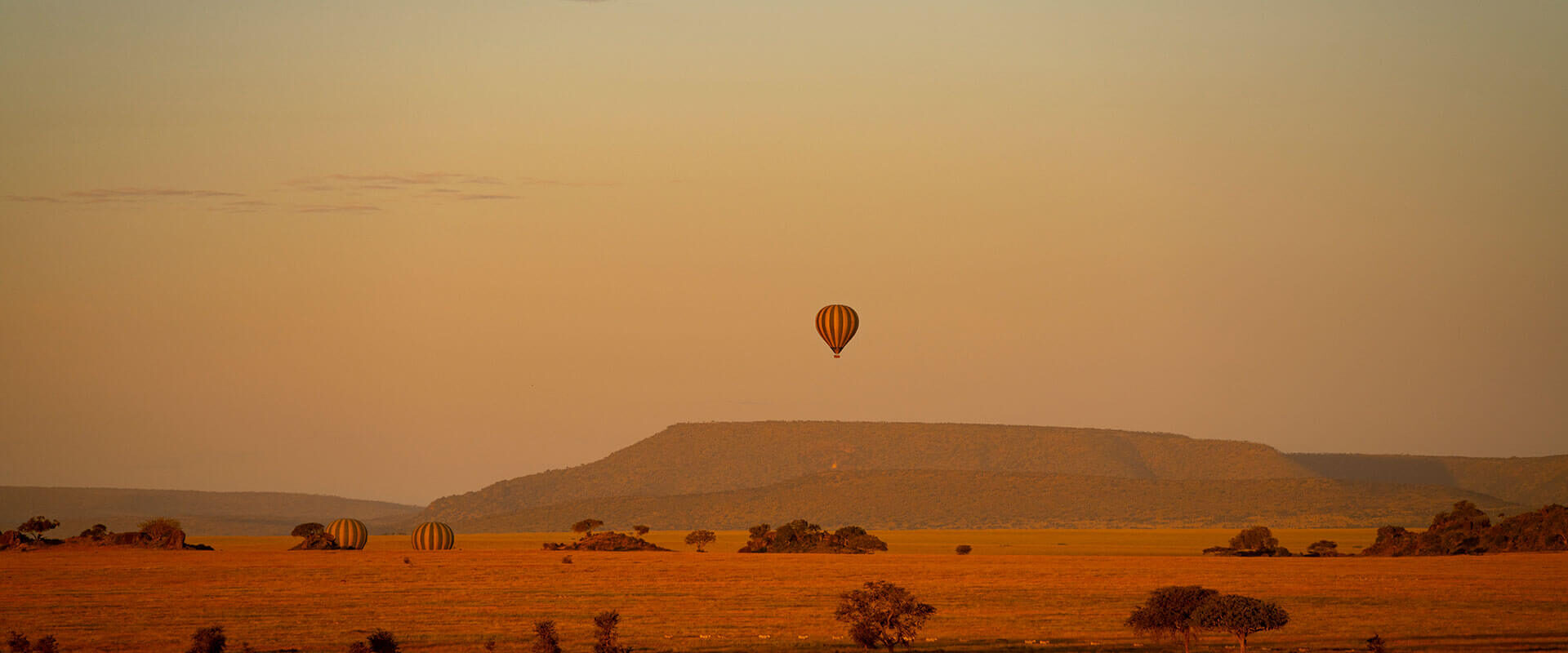 Luftballon i solnedgang over afrikansk landskab