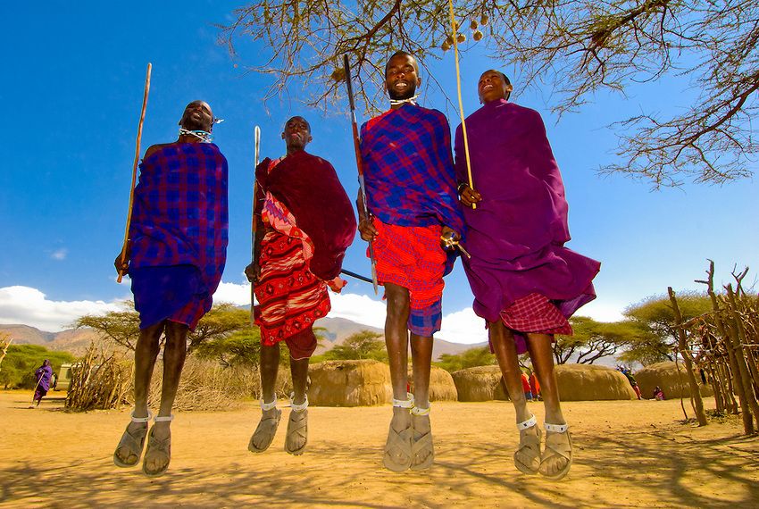 Fire mænd klædt i traditionelle dragter i en Masai-landsby