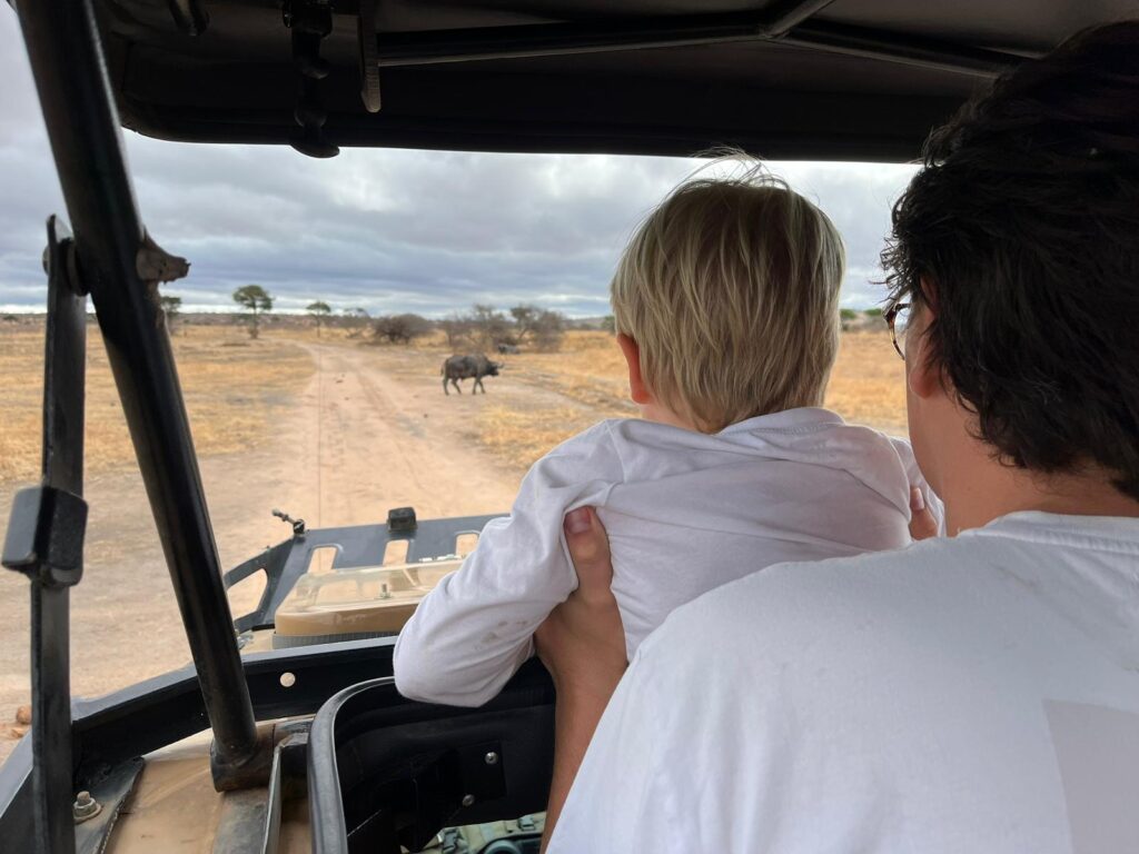 Barn på safari i Safari jeep i Kenya. Bliver holdt af sin far.