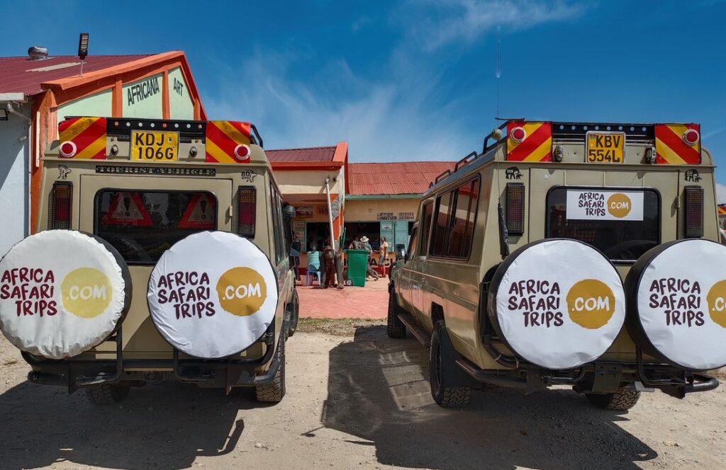 To af Afrika Safari Rejsers egne safarijeeps foran et hus i Afrika