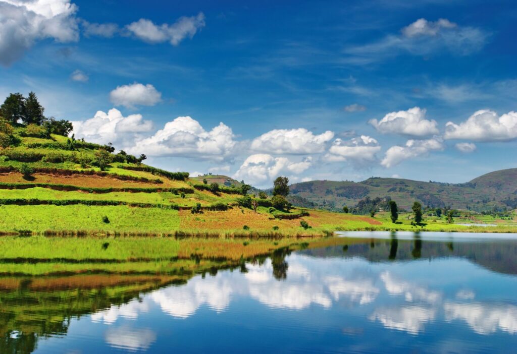 Bunyonyi-søen i Uganda med blå himmel og grønne bakker i baggrunden